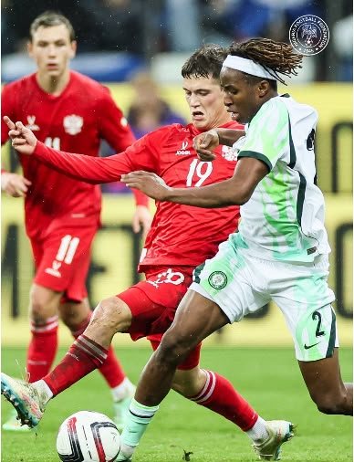 Super Eagles player challenges a Russia opponent during the friendly