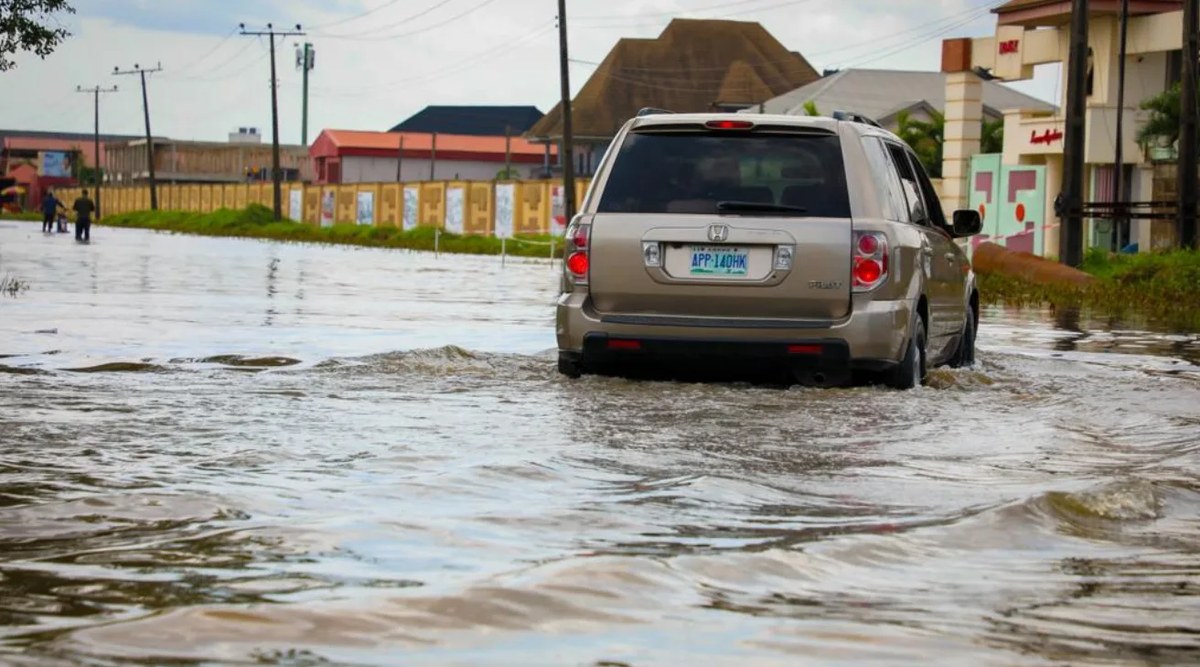 A car driving through floodwater on a flooded road