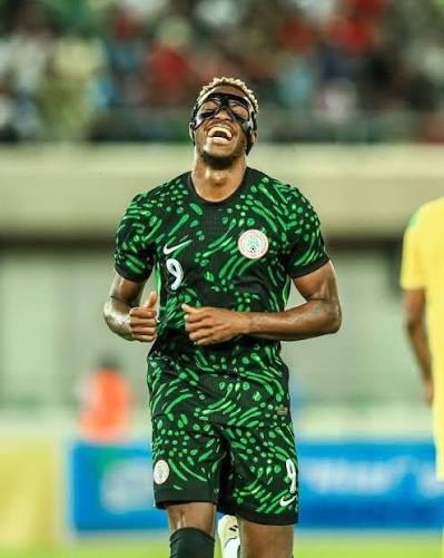 Super Eagles striker in the green Nigeria jersey, smiling during a match