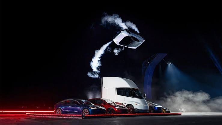 Tesla Roadster flipping in mid-air above a lineup of Tesla vehicles at the SpaceX reveal